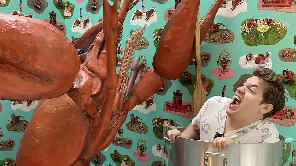 Josh screaming in a large stock pot being cooked by a giant lobster.